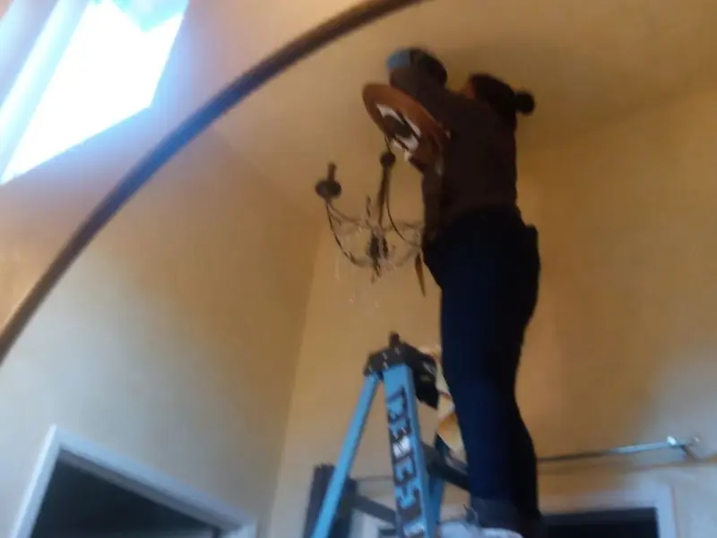 Electrician installing a chandelier in a Oldsmar residence